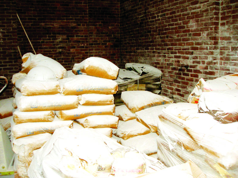 Bags of Sodium Flourosilicate sits piled up nearly five feet high in a back room of the old water treatement plant on Water Street just yards away  from the Merrimack River. The room and everything in it is covered in what looks like snow, but is actually a dangerous and corrosive Sodium  Flourosilicate chemical from broken bags of the substance. Above right, 50 gallon drums of toxic chemicals illegally stored at the plant.