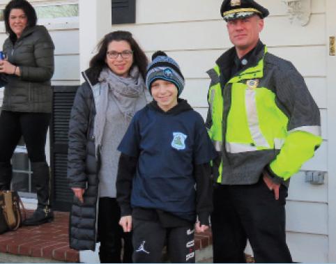 Stacy Abato, Vice President of Cops for Kids with Cancer, 11 year old Nathan Scanlon, and North Andover Police Chief Charles Gray. Nathan was given a ride in a police cruiser to the station where he and his family were presented a check for $5,000 and some needed items